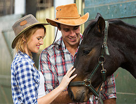 Farming couple patting a horse